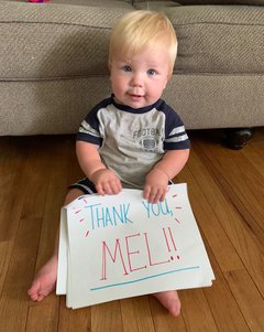 A photo of Jack holding a sign thanking Mel for her care.